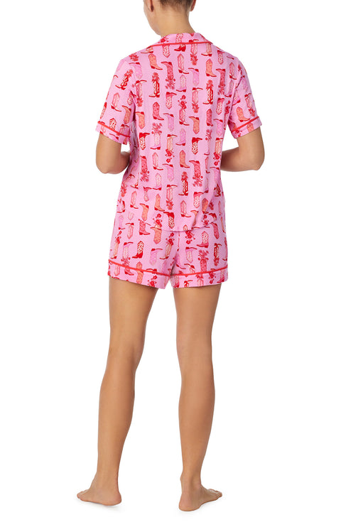 A lady wearing pink short sleeve teagan boxer set with blushing cowgirl print