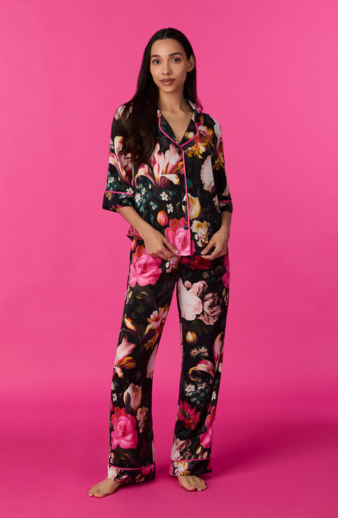 A lady wearing quarter sleeve Gramercy Woven Pj Set In Midnight Garden with black floral print.