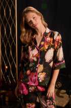 A lady wearing quarter sleeve Gramercy Woven Pj Set In Midnight Garden with black floral print.