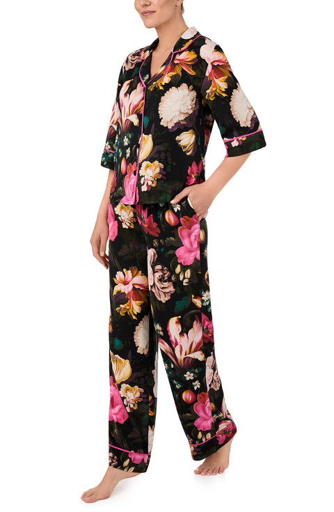 A lady wearing quarter sleeve Gramercy Woven Pj Set In Midnight Garden with black floral print.