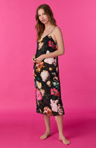 A lady wearing sleeveless Addison Woven Maxi Slip In Midnight Garden with black floral print.