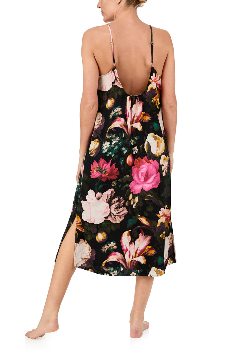 A lady wearing sleeveless Addison Woven Maxi Slip In Midnight Garden with black floral print.