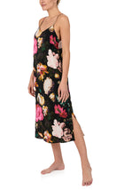 A lady wearing sleeveless Addison Woven Maxi Slip In Midnight Garden with black floral print.