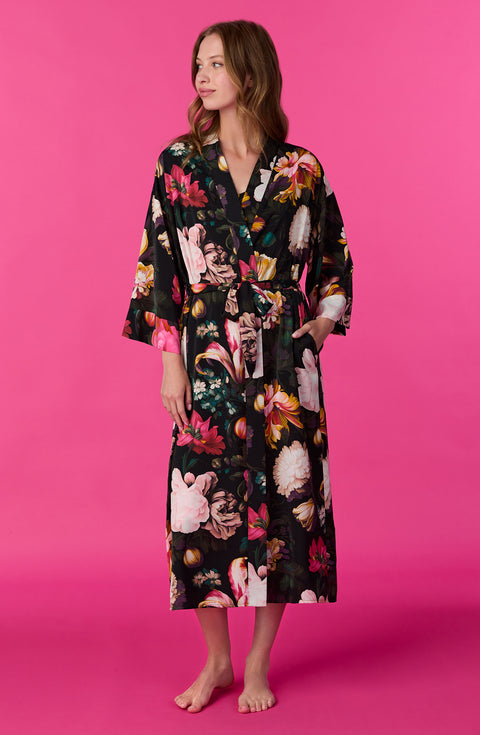 A lady wearing Lydia Woven Maxi Robe in Midnight Garden with black Floral print