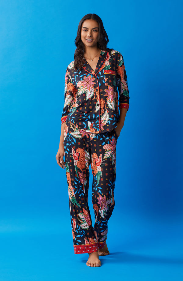 A lady wearing black quarter sleeve reagent pj set with jungle blooms print.