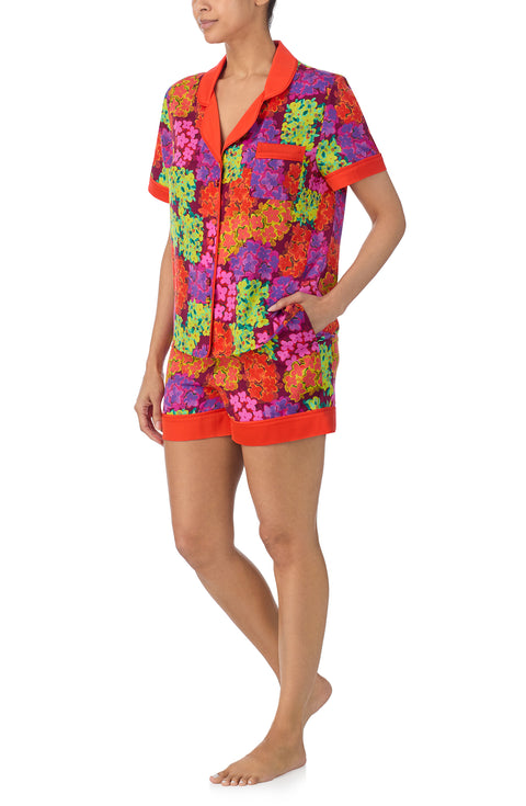 A lady wearing multi color short sleeve chelsea short pj set with electric floral pj set.