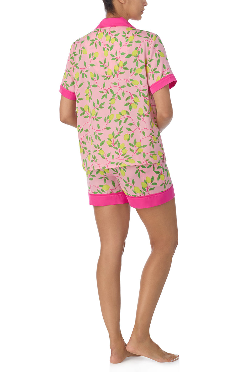 A lady wearing pink short sleeve chelsea short pj set with pink lemonade print.